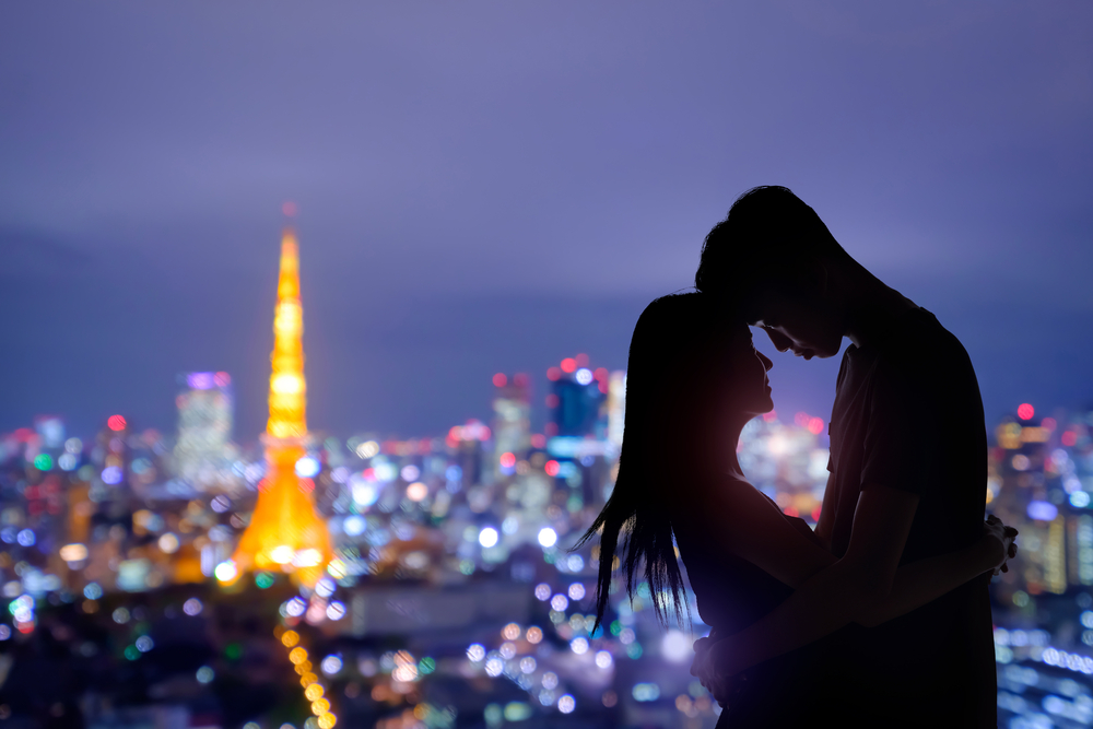 夜景をバックに抱き合うカップル