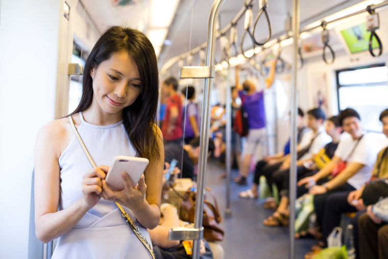 電車内でスマホを使う女性